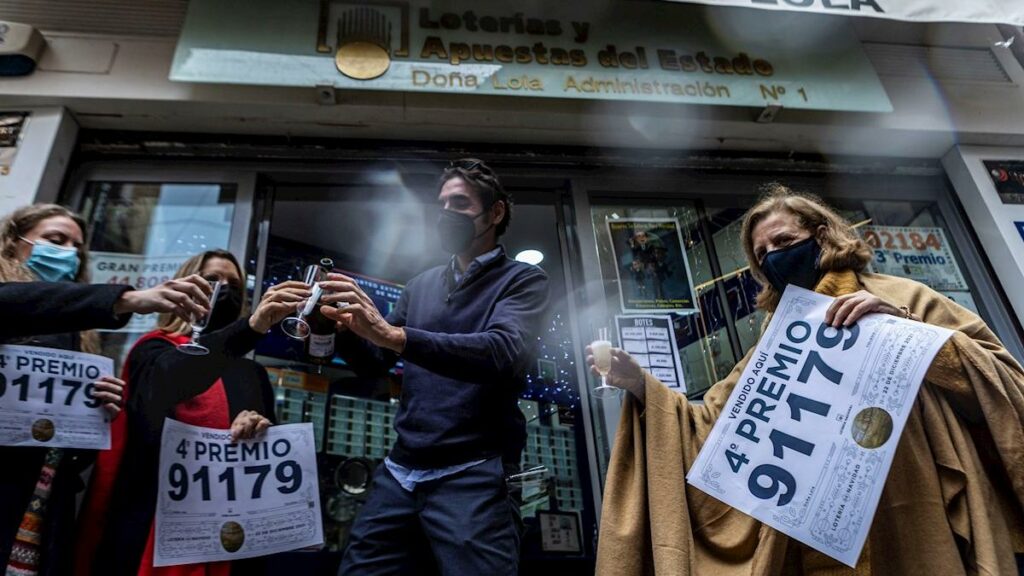 Trabajadores de la administración de lotería Doña Lola en Toledo celebran la venta del número 91179 agraciado con el cuarto premio de la lotería de navidad /Efe