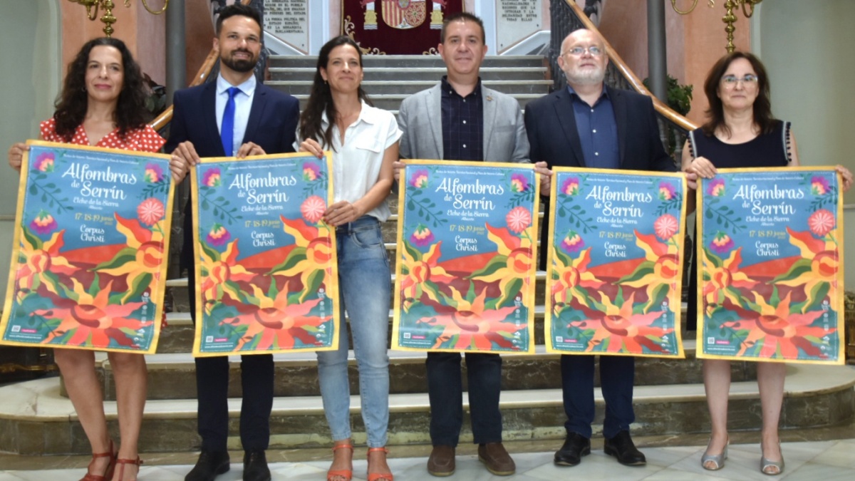 Foto de familia con el cartel de las Alfombras de Serrín de Elche de la Sierra por el Corpus 2022