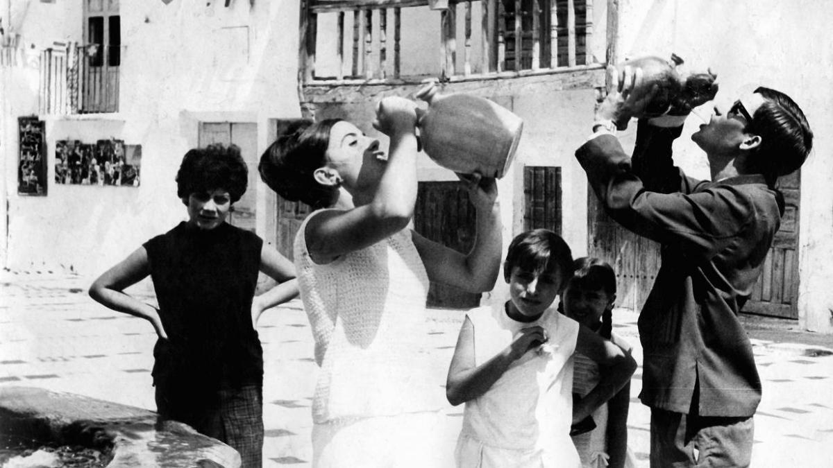 Grupo de personas bebiendo agua en botijos en un caluroso día de verano en Enguídanos (Cuenca). Década de los años 60. Fondo Los Legados de la Tierra. Archivo de la Imagen de Castilla-La Mancha / Foto: JCCM