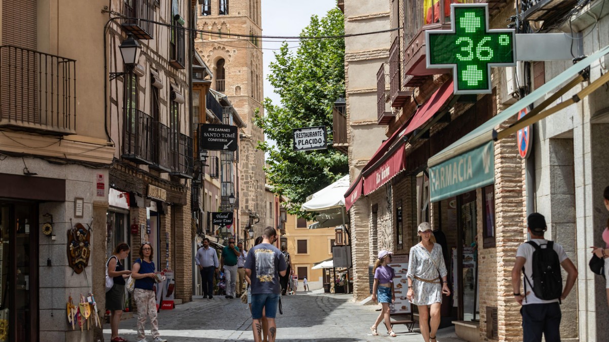 TOLEDO, 18/07/2024.- Varios turistas pasean por una calle, este jueves en Toledo. Los ayuntamientos de los principales municipios de Castilla-La Mancha han activado sus protocolos para paliar los riesgos ante la ola de calor que ha llegado a la comunidad autónoma y, entre otras medidas, han adelantado los horarios de sus trabajadores para evitar el calor más extremo. EFE/Ángeles Visdómine