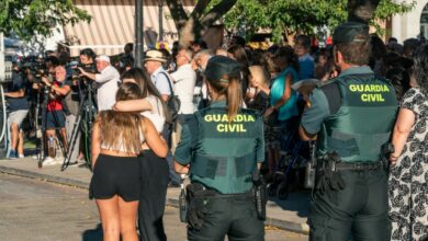 Dos agentes de la Guardia Civil observan a dos chicas abrazadas durante el minuto de silencio por el asesinato de un menor, en la puerta del Ayuntamiento de Mocejón, a 18 de agosto de 2024, en Mocejón, Toledo, Castilla-La Mancha (España). El Ayuntamiento de Mocejón ha decretado tres días de luto oficial por el asesinato en la mañana de hoy de un menor de 11 años, que se encontraba jugando al fútbol junto a otros niños de la localidad en el campo de fútbol municipal 'Ángel Tardío' cuando fue agredido con un objeto punzante. 18 AGOSTO 2024;ASESINATO;MENOR;NIÑO APUÑALADO;TOLEDO;CRIMEN;MINUTO DE SILENCIO;GUARDIA CIVIL Juan Moreno / Europa Press 18/8/2024