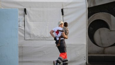 (Foto de ARCHIVO) Una persona de la Cruz Roja sostiene a un menor, en el Puerto de la Restinga, a 28 de noviembre de 2024, en El Hierro, Santa Cruz de Tenerife, Tenerife, Canarias (España). Un cayuco con 136 personas a bordo ha sido localizado a 10 millas de la Isla de El Hierro. Salvamento Marítimo ha salido a su rescate y lo ha traído hasta el puerto de La Restinga donde han desembarcado 40 mujeres y 17 menores. Muchos de estos niños de muy corta edad incluyendo un recién nacido han viajado en un bote en muy malas condiciones y han llegado muy fatigados al puerto. La embarcación de madera viene de Senegal. Antonio Sempere / Europa Press 28 NOVIEMBRE 2024;CAYUCO;MIGRANTES;INMIGRACIÓN;INMIGRANTES;PATERA;SALVAMENTO; 28/11/2024